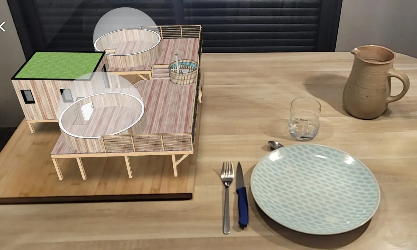 A SketchUp project placed on a table, seen through a phone.